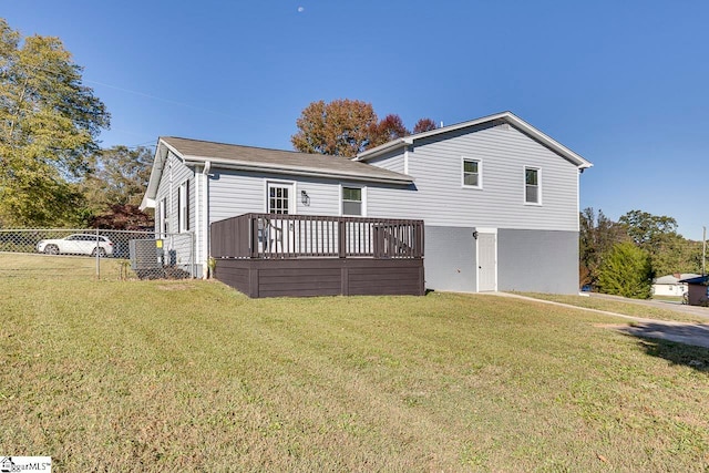 view of front facade with a wooden deck and a front yard