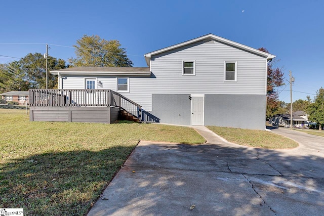 back of house with a deck and a lawn