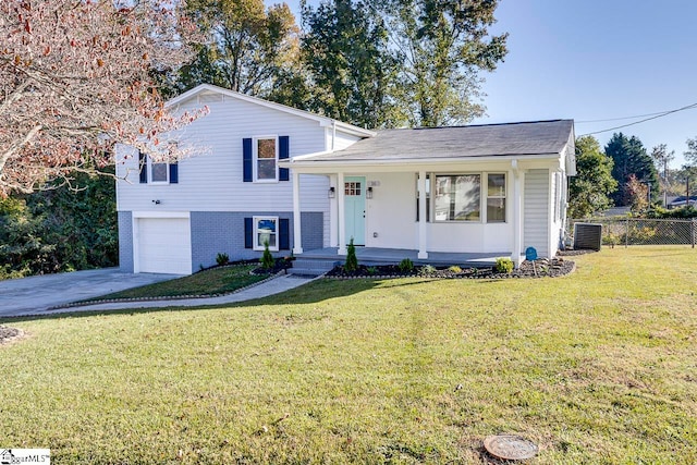 split level home with cooling unit, a garage, and a front lawn