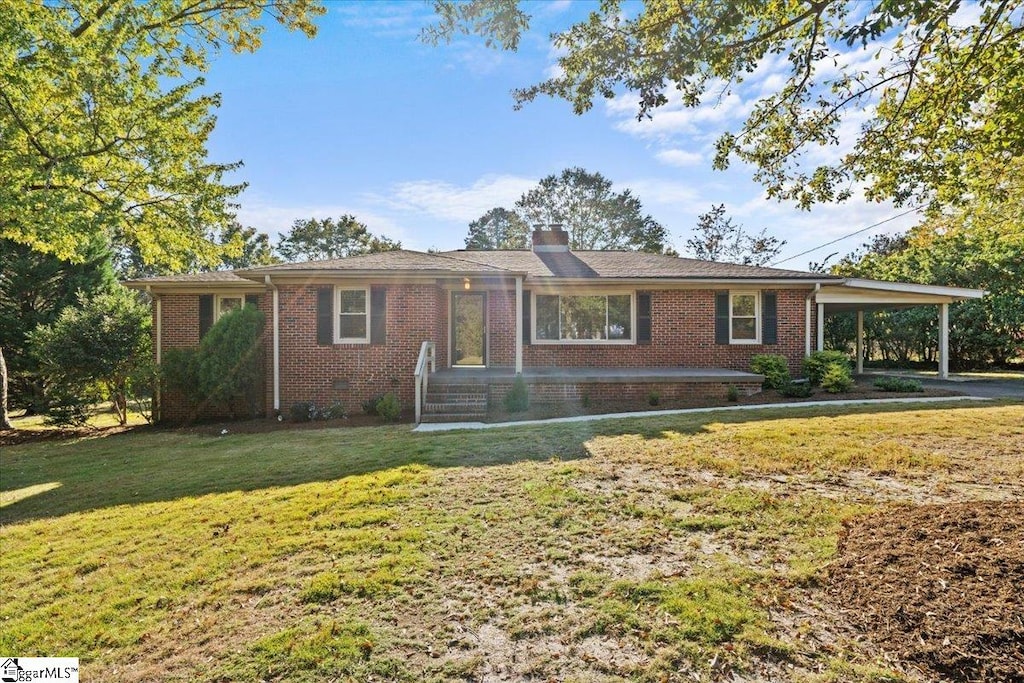 ranch-style house featuring a carport and a front lawn