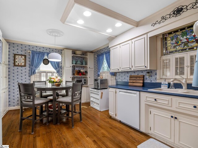 kitchen with white cabinetry, white dishwasher, a wealth of natural light, and decorative light fixtures