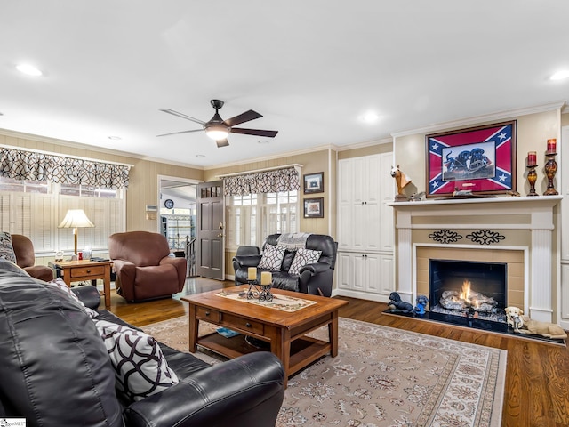 living room featuring crown molding, wood-type flooring, and ceiling fan