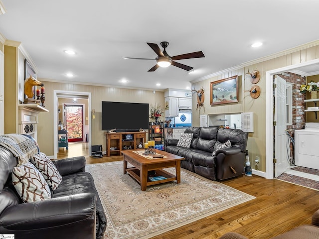 living room featuring washer / dryer, crown molding, hardwood / wood-style flooring, and ceiling fan