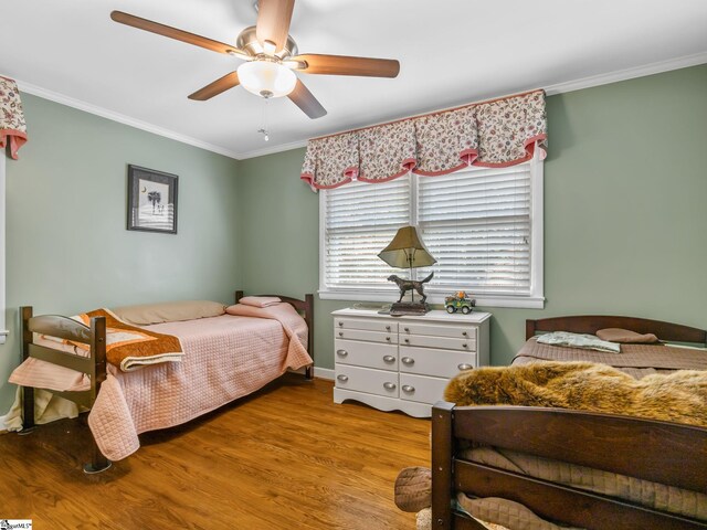 bedroom featuring ornamental molding, light wood-type flooring, and ceiling fan