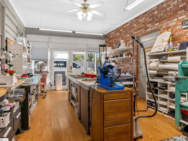 kitchen featuring brick wall, light hardwood / wood-style floors, and ceiling fan