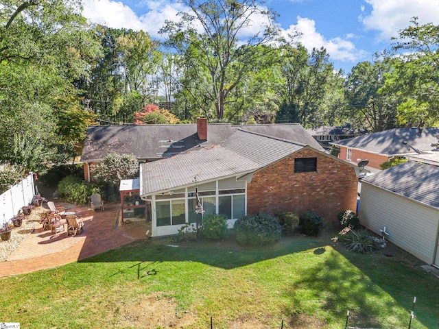 back of house with a patio area and a lawn