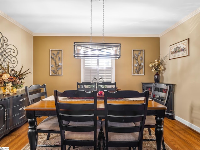 dining space with crown molding, hardwood / wood-style floors, and a chandelier