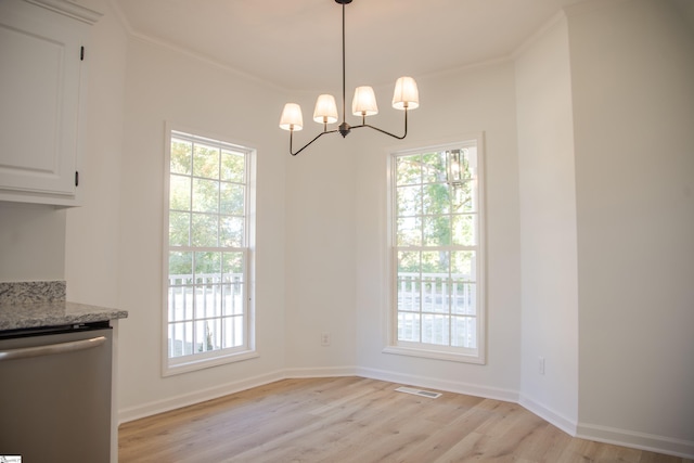 unfurnished dining area with a chandelier, crown molding, and light hardwood / wood-style floors