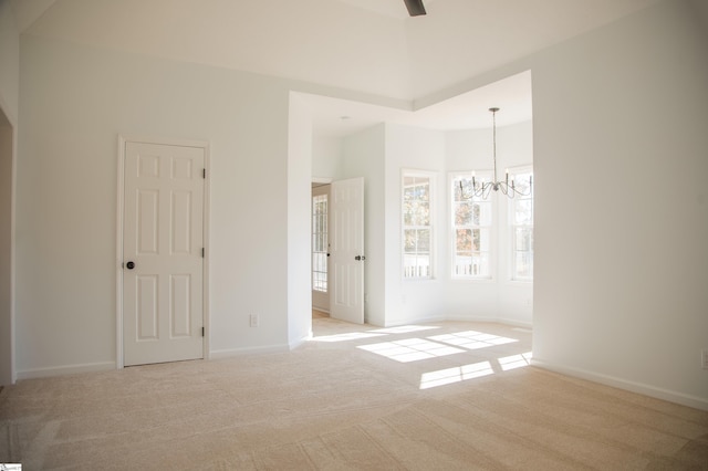 unfurnished bedroom with ceiling fan with notable chandelier and light colored carpet