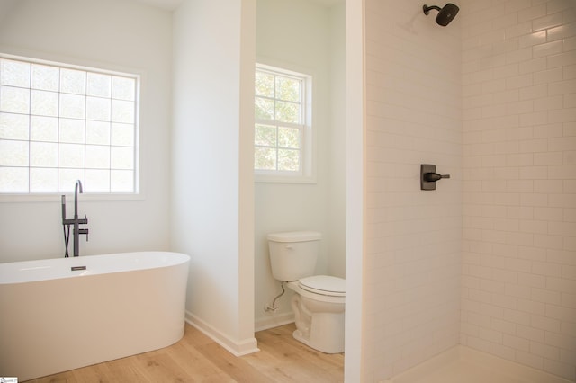 bathroom with toilet, hardwood / wood-style flooring, and shower with separate bathtub