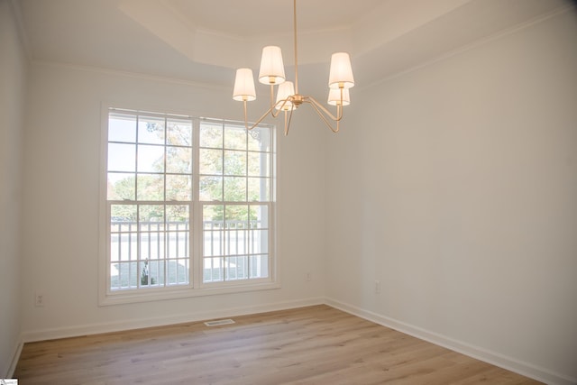 unfurnished room featuring light hardwood / wood-style flooring, a notable chandelier, and crown molding