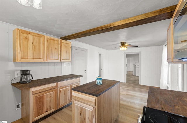 kitchen featuring light brown cabinetry, a kitchen island, light hardwood / wood-style floors, ceiling fan, and beamed ceiling