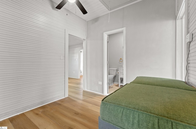 bedroom featuring connected bathroom, a high ceiling, wood-type flooring, and ceiling fan