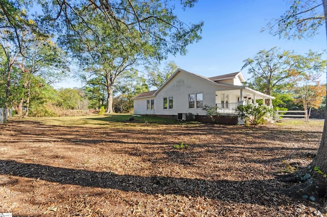 view of home's exterior with covered porch and cooling unit