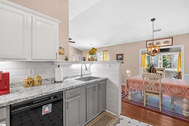 kitchen featuring lofted ceiling, dishwasher, sink, white cabinets, and light hardwood / wood-style floors