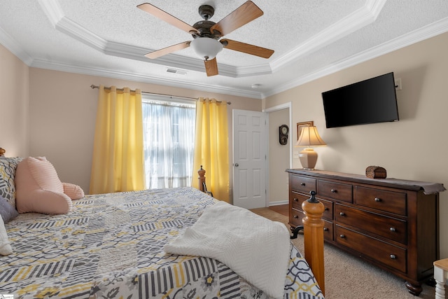 carpeted bedroom featuring ornamental molding, a textured ceiling, a tray ceiling, and ceiling fan