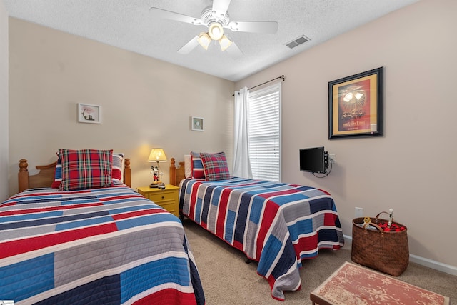 bedroom with a textured ceiling, carpet flooring, and ceiling fan