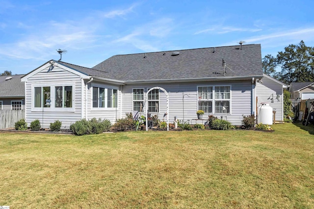 rear view of house featuring a lawn