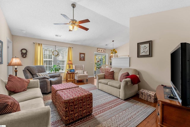 living room with ceiling fan, a textured ceiling, vaulted ceiling, and hardwood / wood-style floors