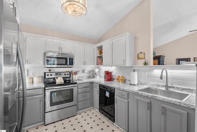 kitchen with gray cabinets, lofted ceiling, stainless steel appliances, and sink