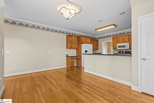 kitchen with white appliances, crown molding, kitchen peninsula, and light wood-type flooring