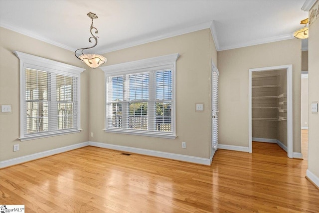 unfurnished dining area featuring crown molding, light hardwood / wood-style floors, and a healthy amount of sunlight