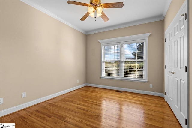 spare room featuring light hardwood / wood-style floors, ornamental molding, and ceiling fan