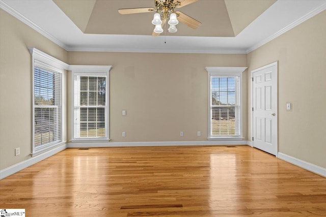 spare room with light hardwood / wood-style floors, ornamental molding, and a wealth of natural light