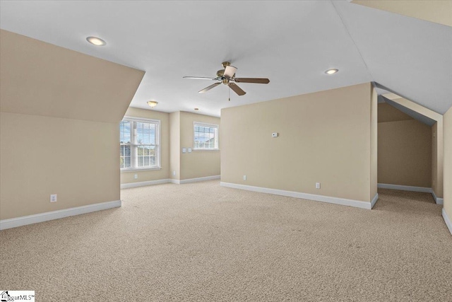 additional living space featuring light carpet, lofted ceiling, and ceiling fan