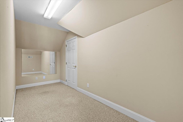 additional living space featuring light carpet and lofted ceiling