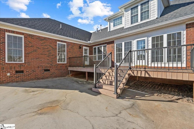 back of property with a deck and a patio area