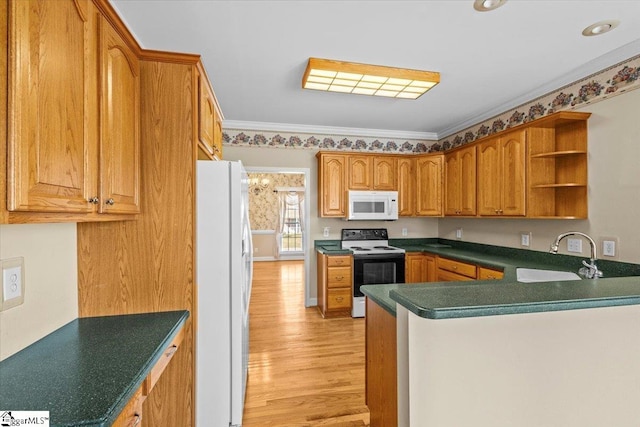 kitchen featuring kitchen peninsula, light wood-type flooring, ornamental molding, sink, and white appliances