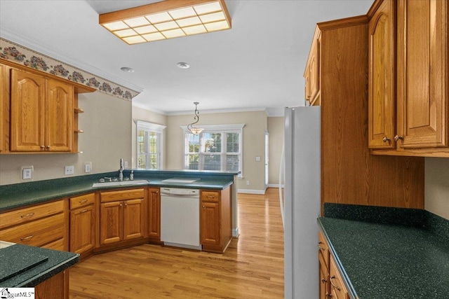 kitchen featuring kitchen peninsula, sink, crown molding, light wood-type flooring, and white appliances