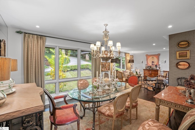 dining room with an inviting chandelier, wood-type flooring, and a fireplace