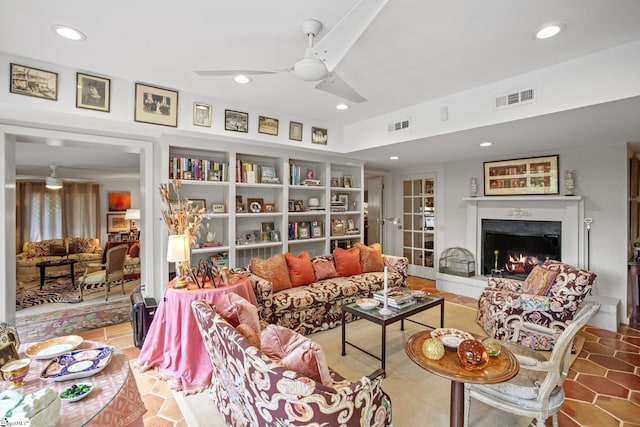 living room with ceiling fan, tile patterned floors, and a fireplace