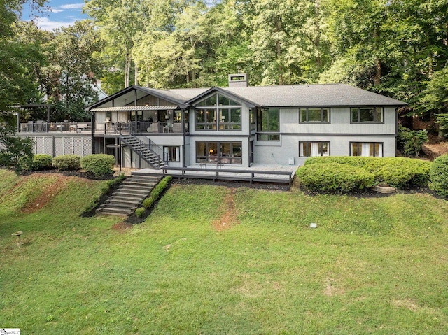 rear view of house with a wooden deck and a yard