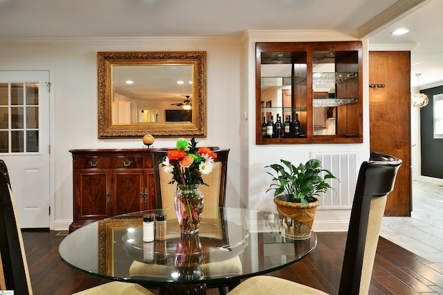 dining area with ornamental molding, dark hardwood / wood-style floors, and ceiling fan