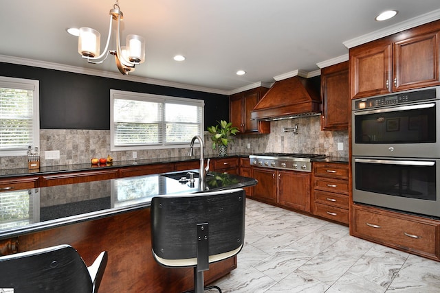 kitchen featuring appliances with stainless steel finishes, premium range hood, pendant lighting, crown molding, and sink