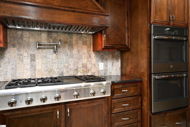 kitchen with custom range hood, stainless steel appliances, and tasteful backsplash