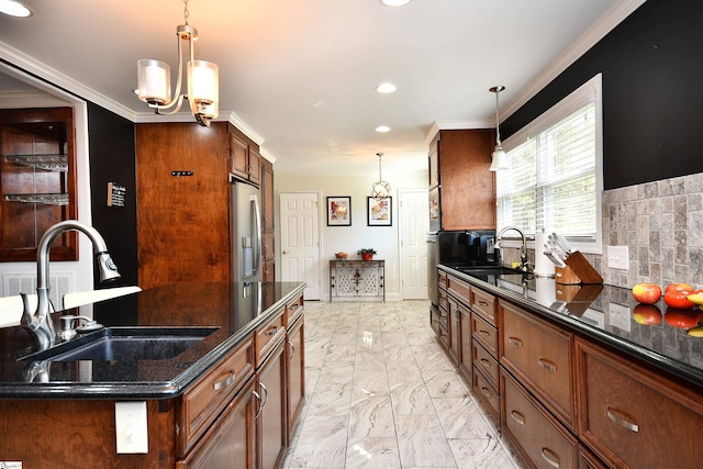 kitchen with stainless steel fridge, sink, and hanging light fixtures