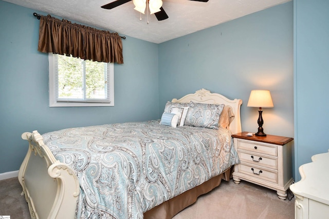 carpeted bedroom with ceiling fan and a textured ceiling