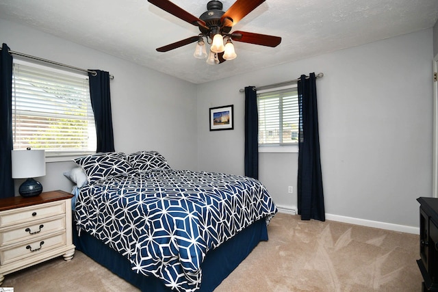 carpeted bedroom featuring a textured ceiling, multiple windows, and ceiling fan