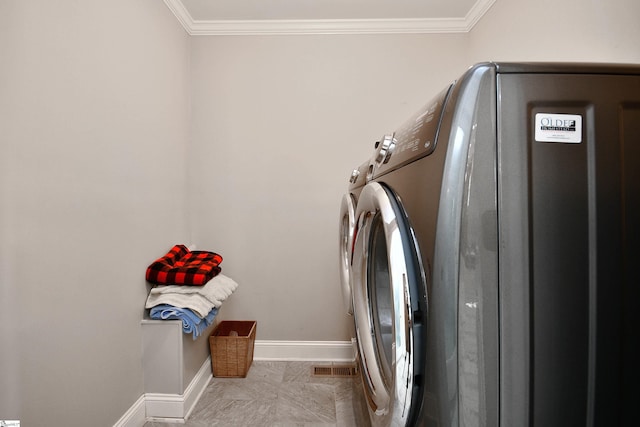 washroom featuring ornamental molding and washing machine and dryer