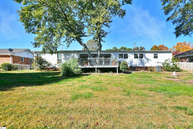 back of property with a yard, a deck, and central AC unit