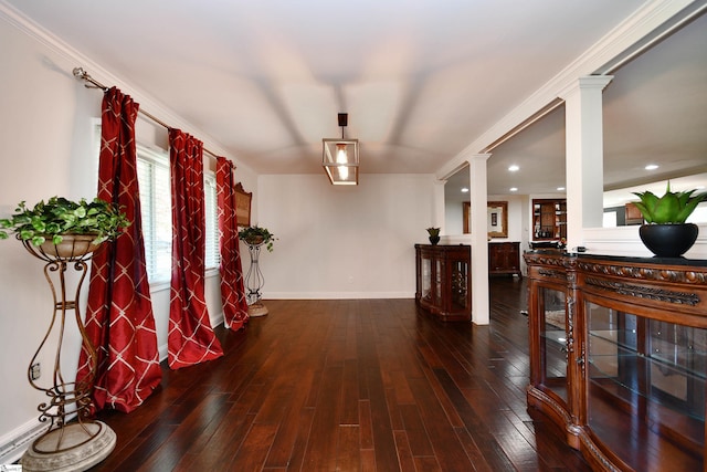 corridor with ornamental molding, decorative columns, and dark wood-type flooring