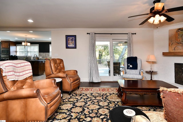 living room with ceiling fan, ornamental molding, a wealth of natural light, and a fireplace