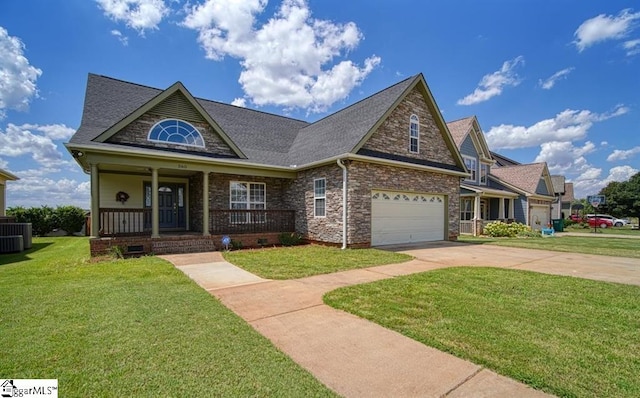 view of front facade with a porch, a front lawn, central AC, and a garage