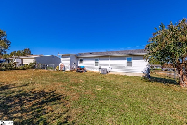 back of property with central air condition unit and a yard