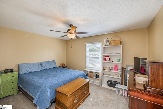 bedroom with ceiling fan, a textured ceiling, and light colored carpet