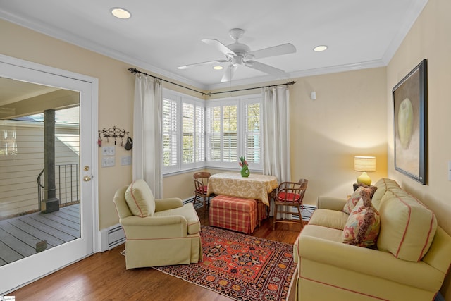 sitting room featuring hardwood / wood-style floors, a baseboard heating unit, crown molding, and ceiling fan